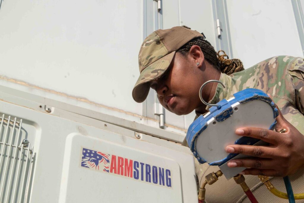 HVAC technician checking refrigerant pressure gauges during a service call