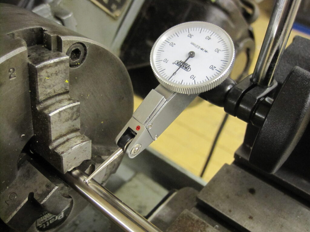 Dial test indicator mounted on a lathe for alignment measurement