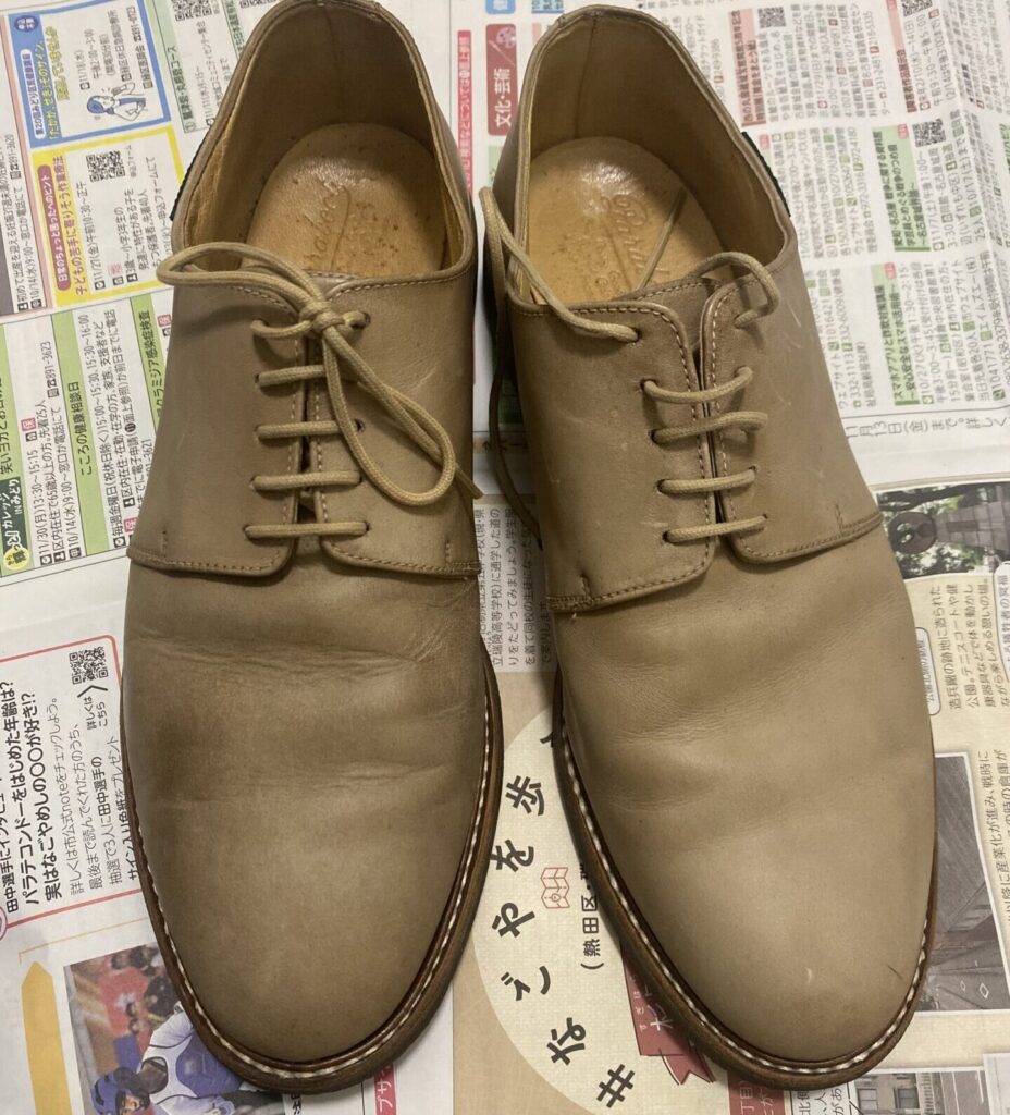 雨シミが片側だけ残った、明るい色のヌバックの外羽根プレーントゥ